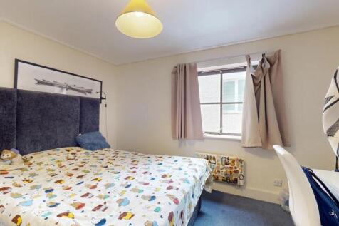 A comfortable double bedroom with a colorful pa...