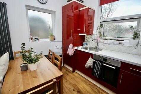 Well-lit modern kitchen featuring sleek red cab...