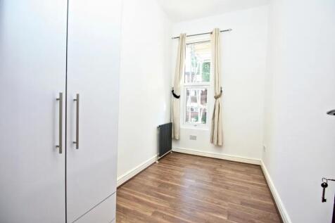 Bright, clean room with wooden flooring and a l...