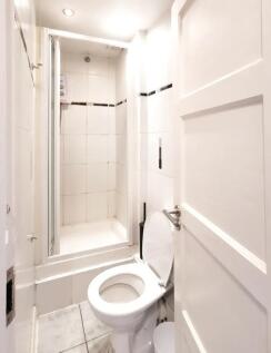 A bright and clean bathroom featuring a white t...