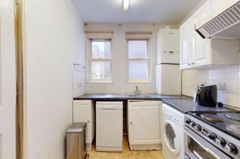A compact kitchen featuring modern appliances i...
