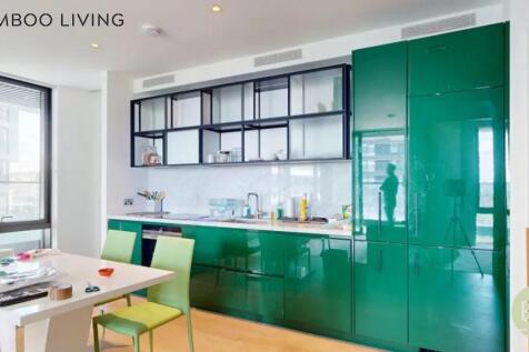 Bright and modern kitchen featuring glossy gree...