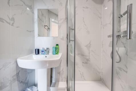 This modern bathroom features elegant marble wa...