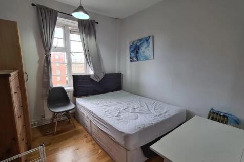 A tidy double bedroom with a large window allow...