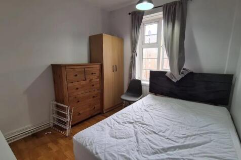 Bright double bedroom with a large window letti...