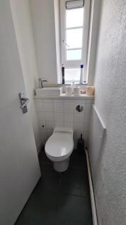 Bright and clean single toilet room featuring a...