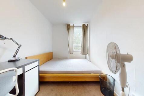 A well-lit double bedroom featuring a wooden be...