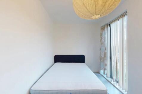 A bright and clean single bedroom featuring a m...
