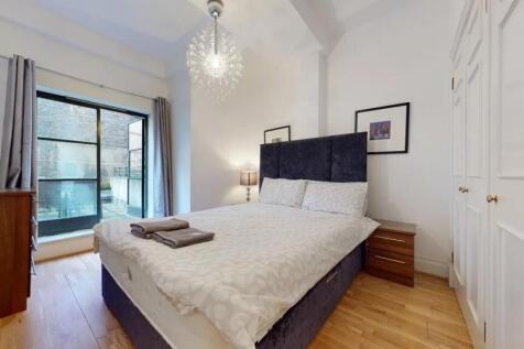 A bright and stylish master bedroom featuring a...