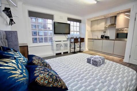 Bright and modern master bedroom featuring a co...