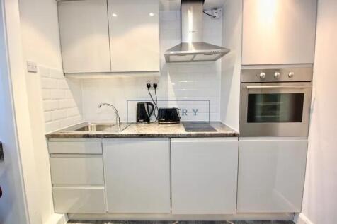Modern compact kitchen with sleek white cabinet...