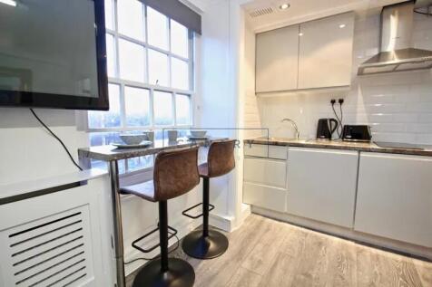 Bright and modern kitchen featuring sleek cabin...