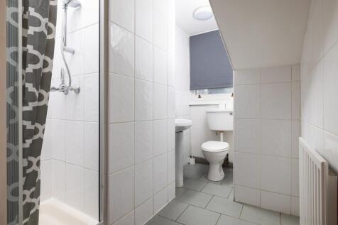 A clean and modern bathroom featuring a shower ...