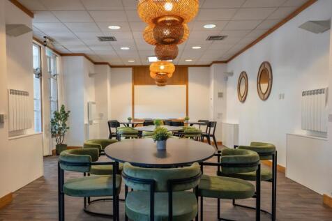Bright and inviting communal workspace featurin...