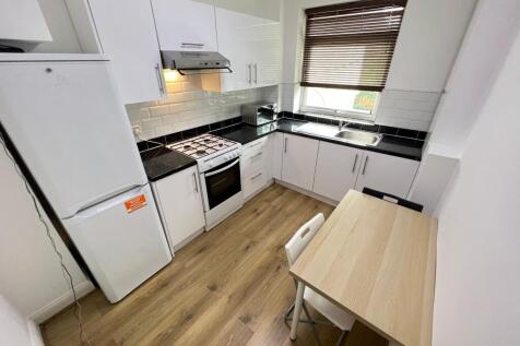 A modern and clean kitchen featuring white cabi...
