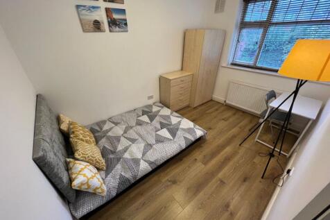 A tidy single bedroom featuring a comfortable b...