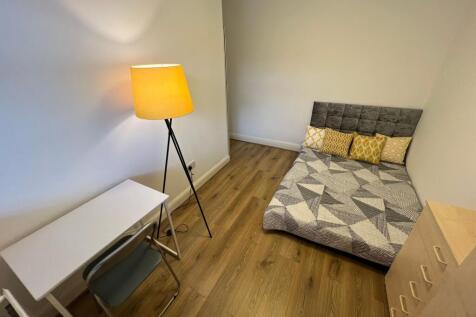 A neatly arranged single bedroom featuring a pa...