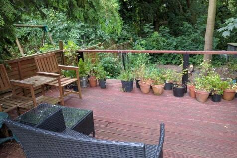 A charming garden deck area featuring comfortab...