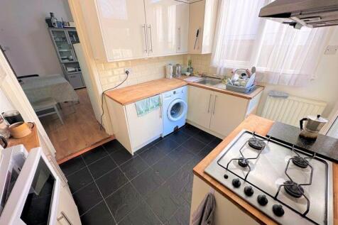 Bright and tidy kitchen featuring modern cream ...