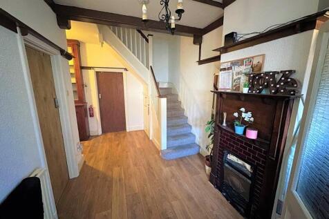 A bright and welcoming hallway featuring wooden...