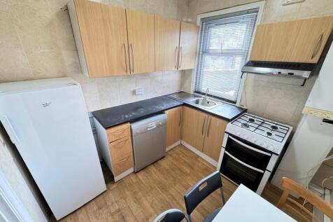 A bright kitchen featuring wooden cabinets, a w...