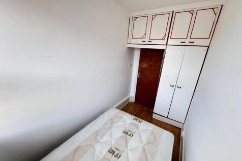 A compact single bedroom with a clean wooden fl...