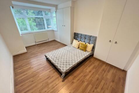 A bright double bedroom featuring a comfortable...
