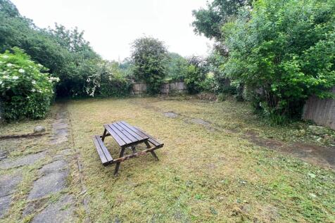 A spacious garden featuring freshly cut grass s...