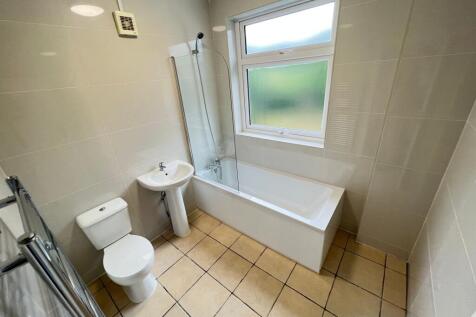 Bright and clean bathroom suite featuring a ful...