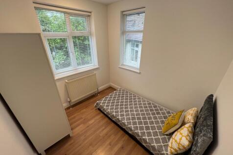 A bright and tidy single bedroom featuring two ...