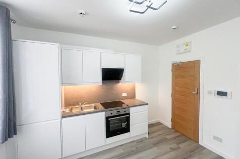 Modern kitchen featuring sleek white cabinetry ...