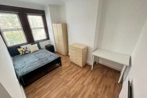 A bright and tidy double bedroom featuring larg...