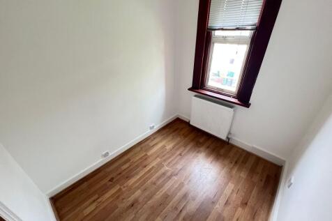 A bright single bedroom featuring wood laminate...
