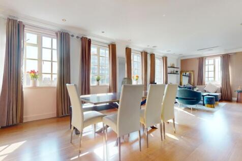 A spacious, bright living room featuring a larg...