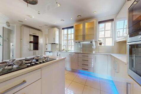 A modern, bright kitchen featuring sleek white ...