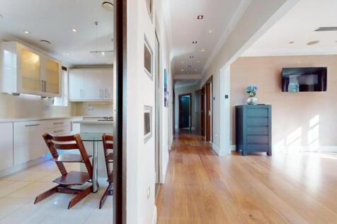 A bright and modern kitchen with sleek white ca...