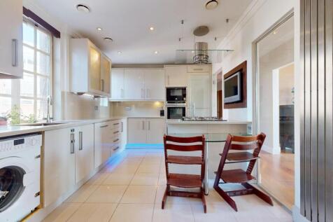 Bright and modern kitchen featuring sleek white...