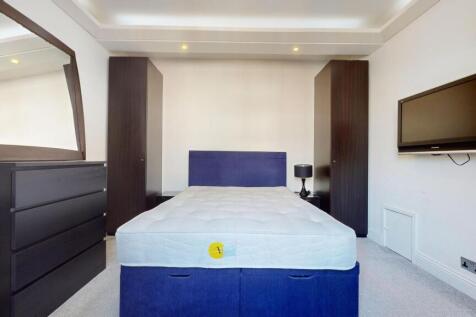 A neat double bedroom featuring a comfortable b...