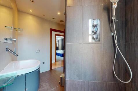 A modern bathroom featuring sleek grey tiles an...