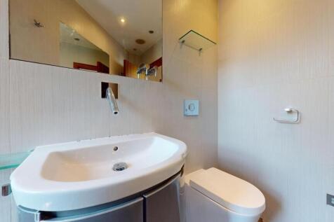A modern bathroom featuring a sleek white sink ...