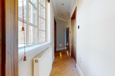A bright and inviting hallway featuring polishe...