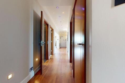 A modern, clean hallway featuring polished wood...