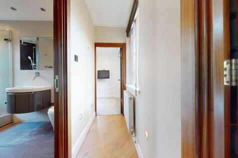 Bright and tidy hallway with wooden flooring an...