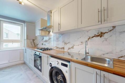 A modern and clean kitchen featuring sleek whit...