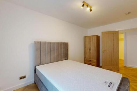 A modern double bedroom featuring a plush grey ...