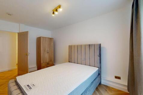 A neat and modern double bedroom featuring a pl...