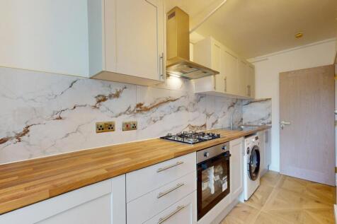 A modern kitchen featuring stylish wooden count...