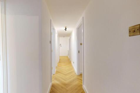 Bright and clean hallway featuring modern chevr...