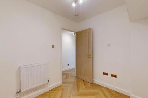 Bright and clean hallway featuring light wood f...