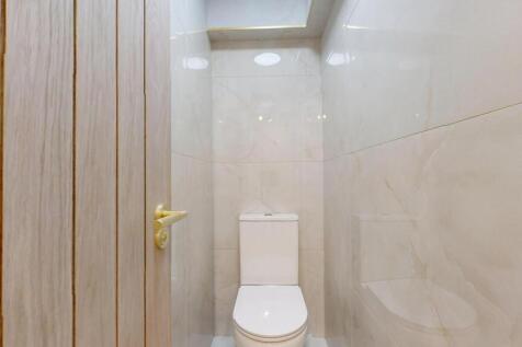 A clean and modern single toilet with light bei...